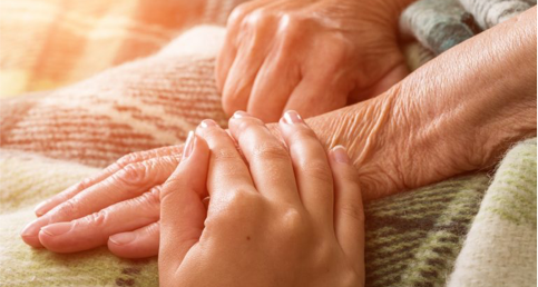 Pflegerhand auf Senioren Hand